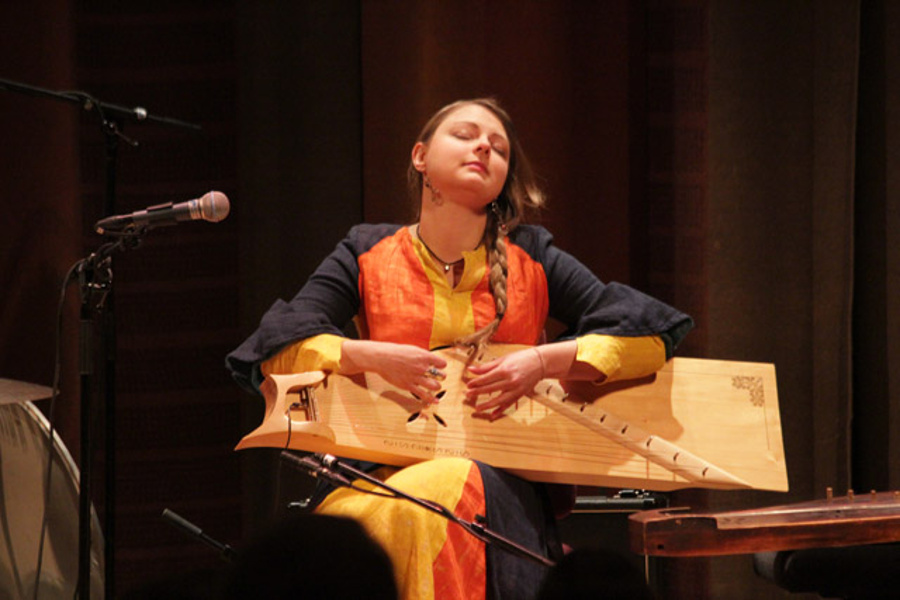 Laima Jansone při hře na strunný nástroj kokle