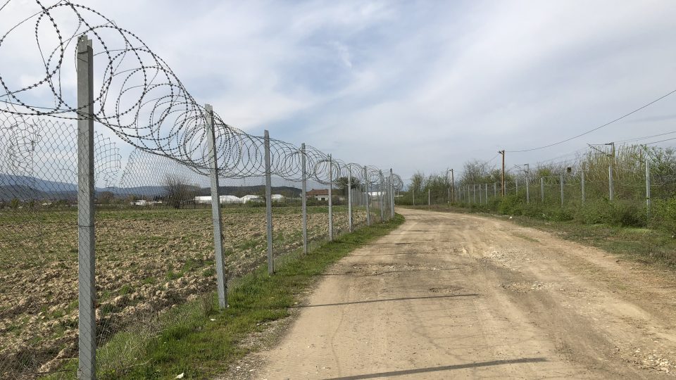 Na zelené hranici je postaven plot s ostnatým drátem