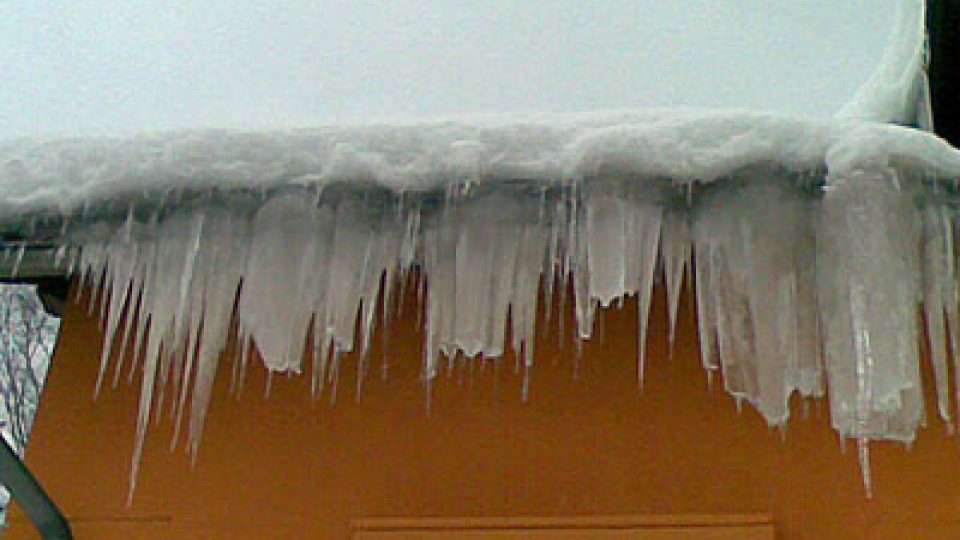 Masy ledu na střeše domu