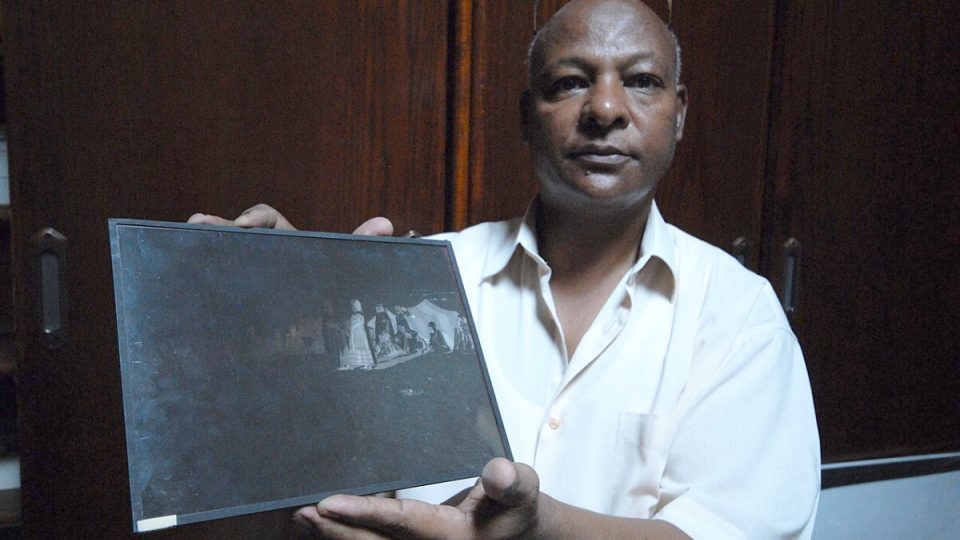 Pan Muhammad ukazuje jeden z původních skleněných negativů Rudolfa Lehnerta