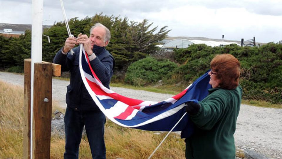 Tim se svou manželkou Jan vztyčují ve větru britskou vlajku