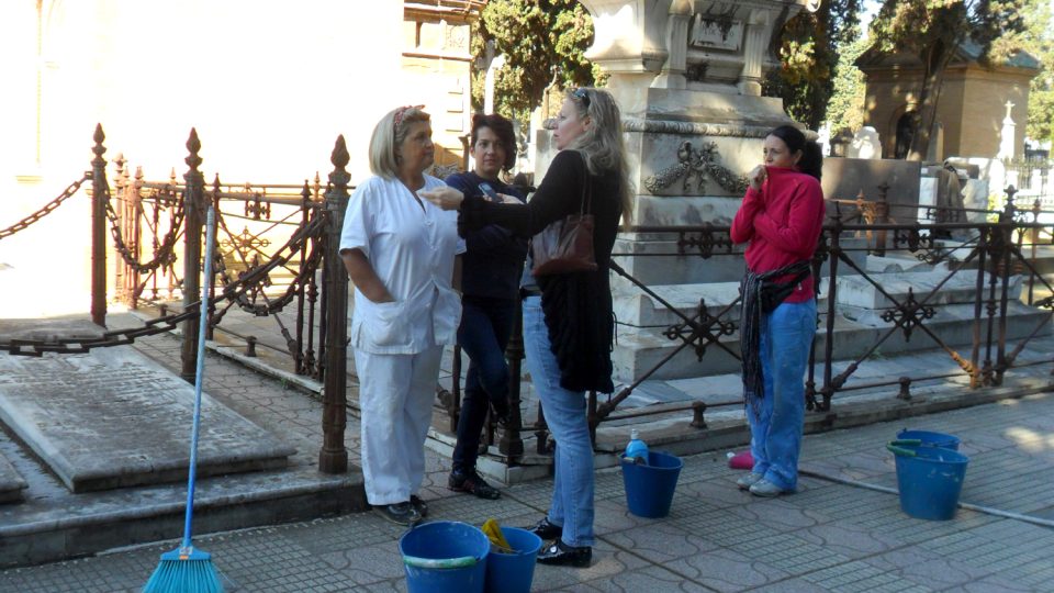 Tři energické ženy s kyblíky, košťaty a čistícími potřebami živě konverzovaly i při čištění hrobů