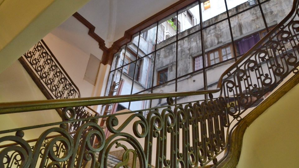 Jedno ze schodišť Paláce Salvo a průhled do málo pohledného vnitrobloku skrz léta rozbité okno