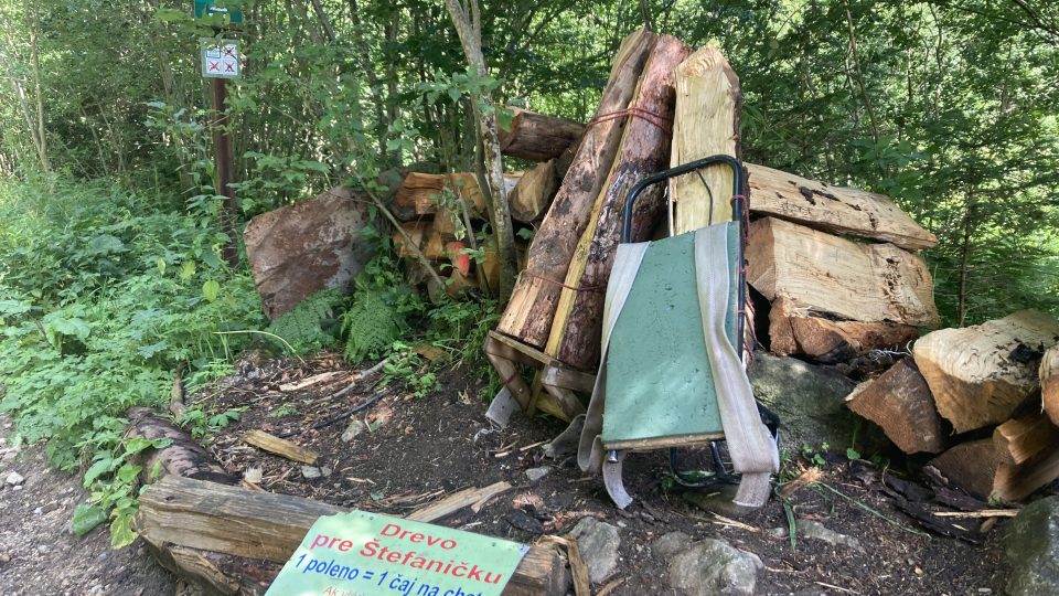 Hned na začátku zelené turistické stezky je hromada těžkých dřevěných špalků a dvě nosičské krosny. Každý turista tak může přispět, aby bylo večer čím zatopit v krbu