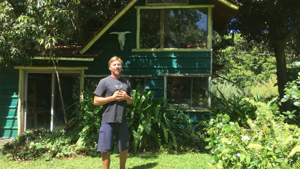 Erik Kučera před svým domem, který postavil z použitých materiálů okolo živého stromu