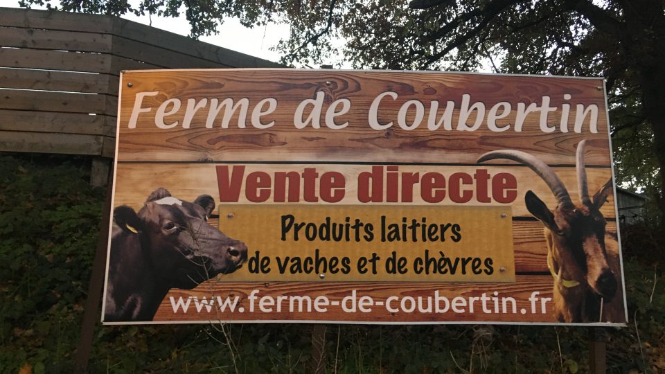 Velký nápis Coubertinova farma uvozuje atmosféru kdákajících kachen a zaparkovaných traktorů