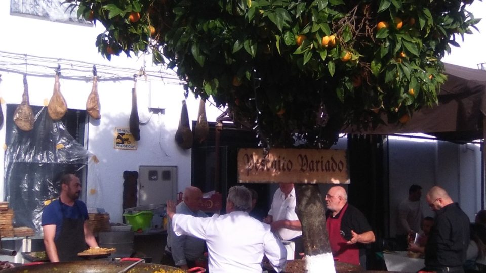 Na náměstí místní pod otevřeným nebem grilují maso a připravují tradiční paellu