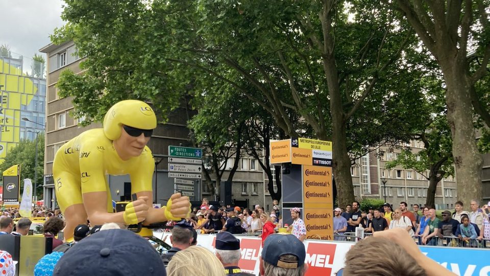 Monumentální cyklista ve žlutém trikotu, který je součástí tradiční reklamní karavany Tour de France
