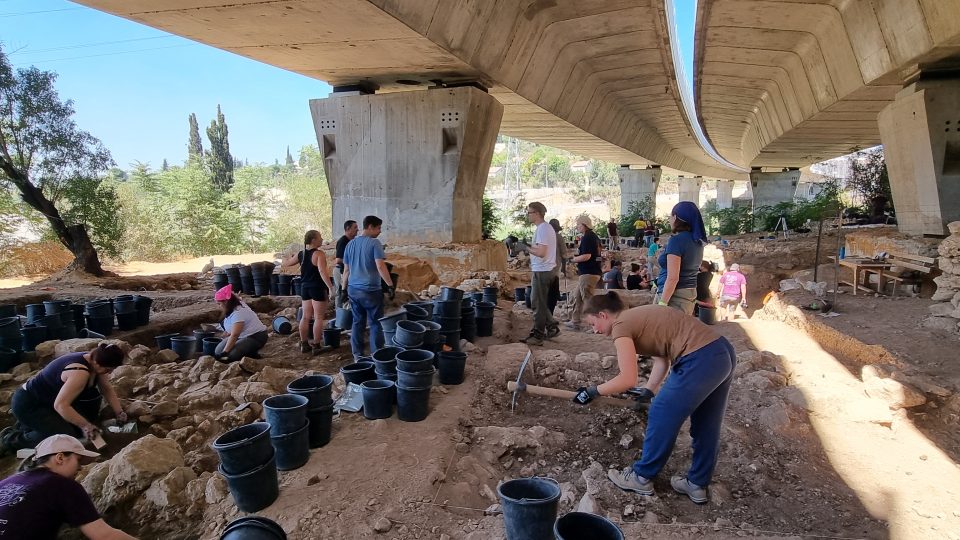 Pod novým dálničním mostem na hlavním tahu z Tel Avivu do Jeruzaléma panuje obrovské hemžení několika desítek lidí