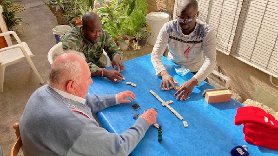 Pán domu hraje s jedním ze svých hostů domino. Raději se obklopuje mladými lidmi, než vrstevníky v sociálním zařízení