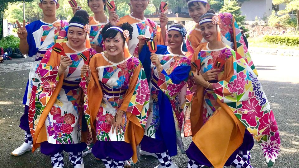 Tanečníci jinak víc než stočlenné mezinárodní skupiny Kizuna. Květiny na jejich kostýmech reprezentují jednotlivé země, ze kterých tanečníci pocházejí