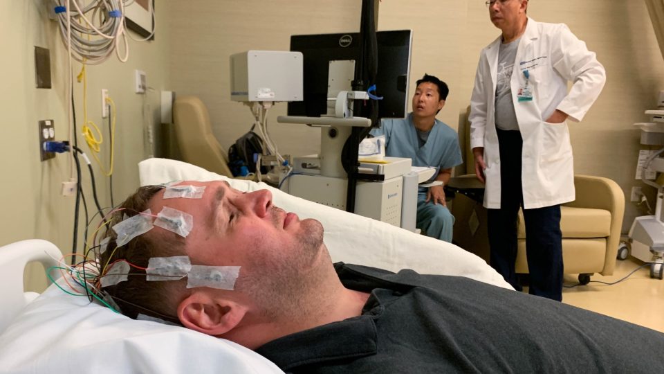 Výzkumníci sledují nervovou aktivitu pacienta Jasona na EEG 
