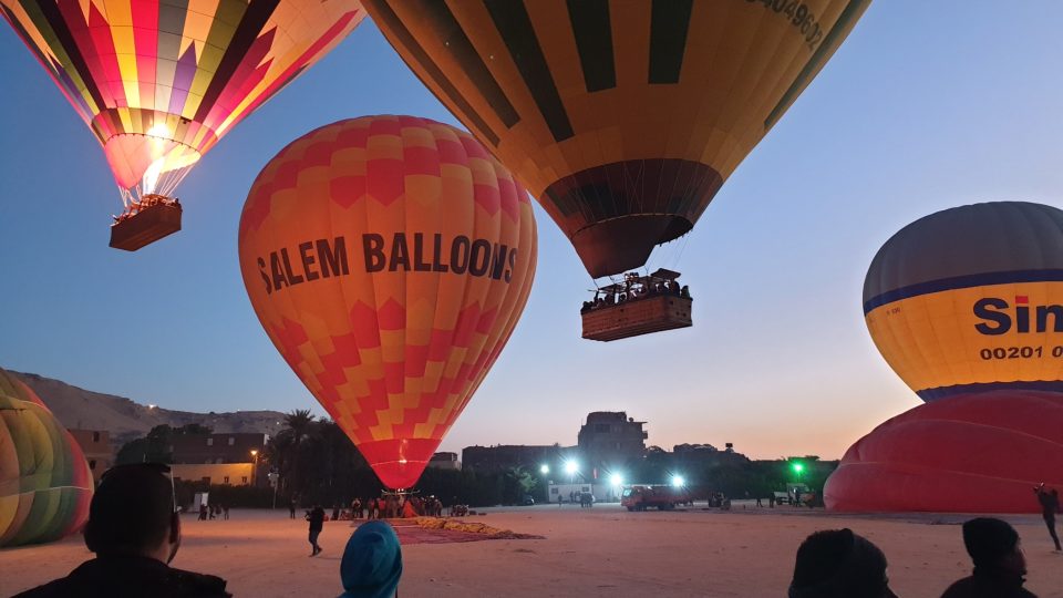 Ještě před východem slunce se asi dvacítka balonů postupně odlepuje od země