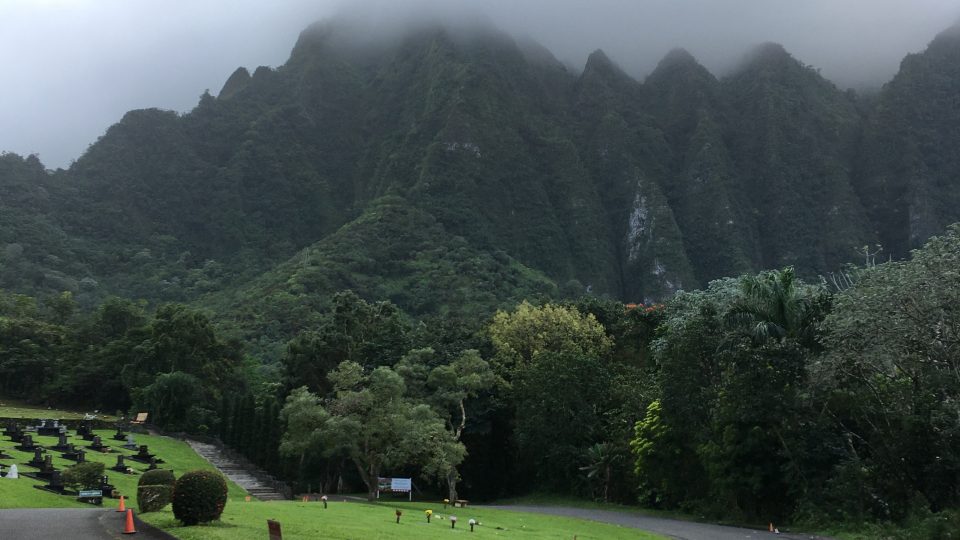 Pohled na Valley of Temples, kde chrám stojí: ostře řezané havajské hory, jejichž špičky se ztrácí v mlze
