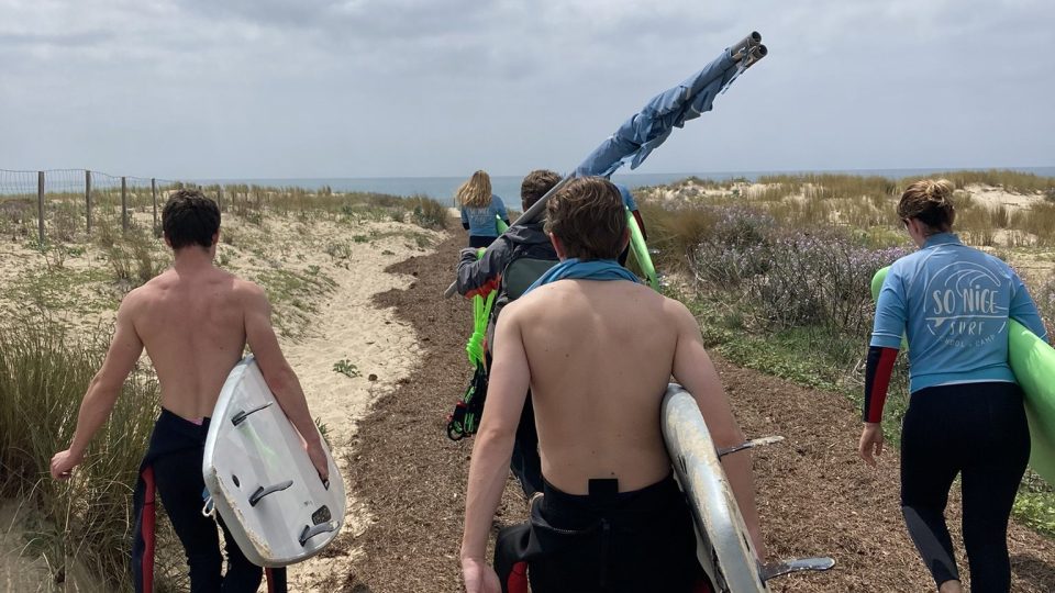 Skupina začínajícícíh surfařů se vydává k moři