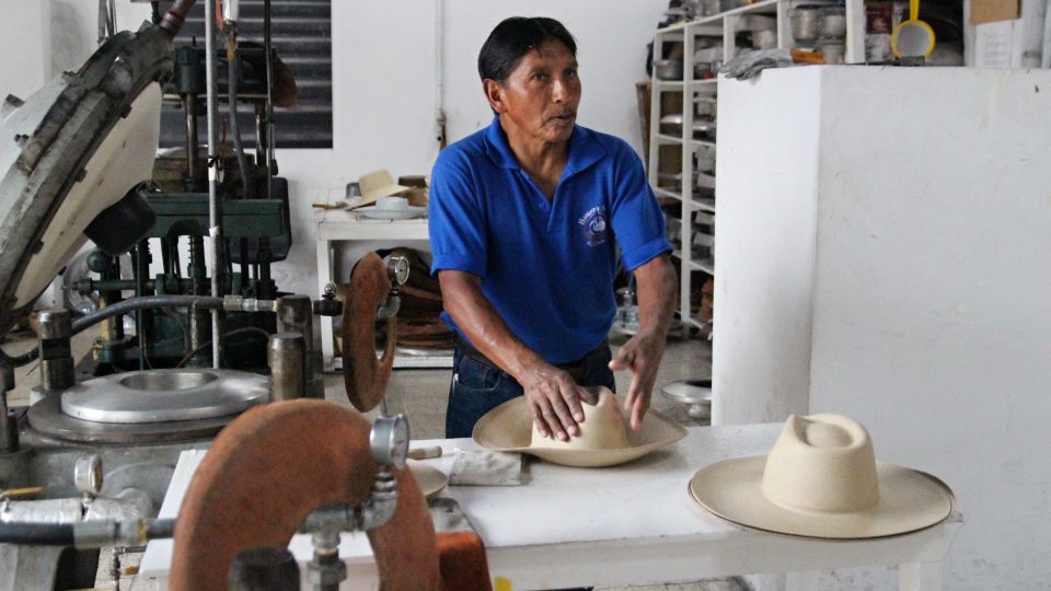 Průvodce Hugo Villota ukazuje, jak výsledný tvar klobouků vzniká na lisu
