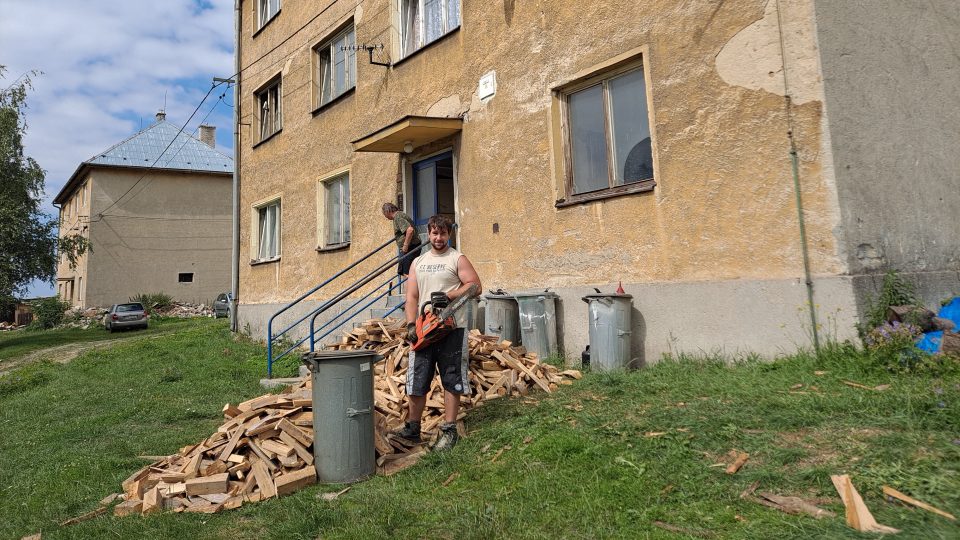 Jan Hajduček chystá dřevo na zimu. Bytové domy vypadají stejně jako ve filmu, který se natáčel před 20 lety.