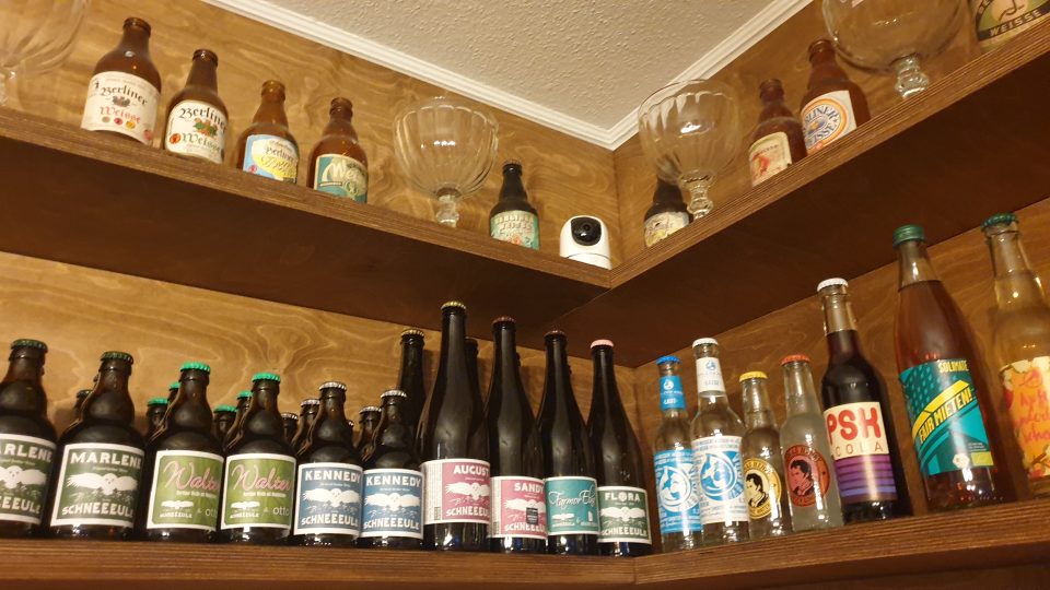 Stěny nad výčepem zdobí staré sklenice a lahve od zaniklých výrobců tohoto specifického piva