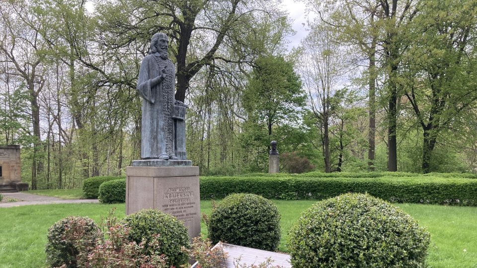 Sochu Jana Amose Komenského obklopují růže, cesmíny a pivoňky