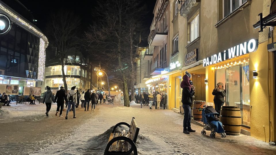 Osvětlené restaurace a obchody působí na sněhu jako kulisa z pohádky