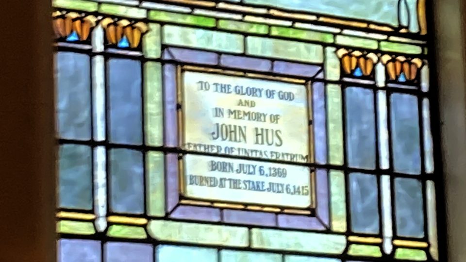 Vitrážová okna s biblickými výjevy doplňují dedikační tabulky na památku Jana Husa a Jana Ámose Komenského