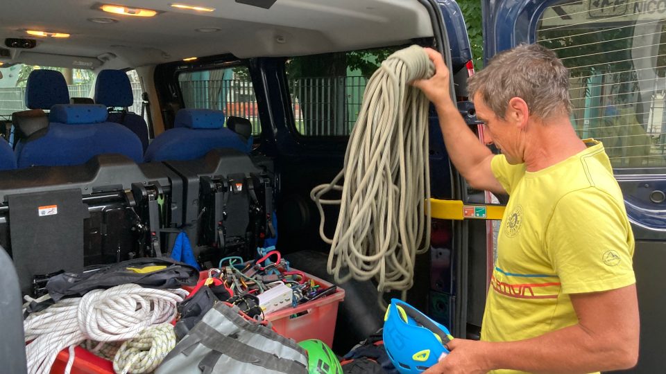 Žluté triko s nápisem Horský vůdce upomíná na profesi, šlachovité paže zase na horolezeckou vášeň