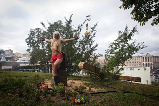 Aktivistka hnutí Femen u pokáceného kříže nad kyjevským náměstím Nezávislosti | foto: Inna Sokolovskaja,  Alexandr Kosmač
