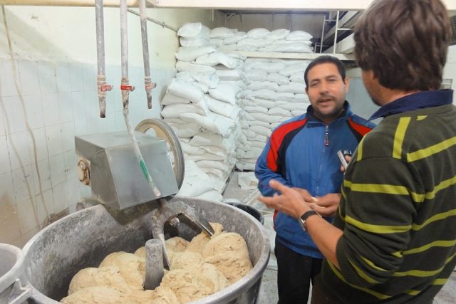 Egyptský pekař Fáris vysvětluje autorovi reportáže technologii hnětení arabské chlebové placky | foto: Štěpán Macháček,  Český rozhlas