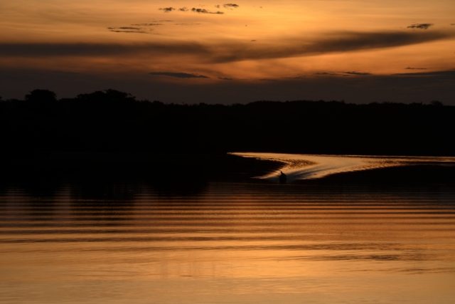Loď přijíždějící k břehu v západu slunce | foto: David Koubek,  Český rozhlas