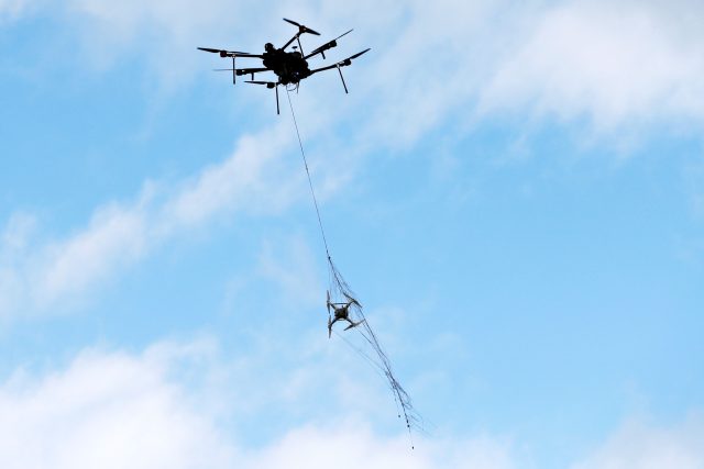 Jednou z možností,  jak zlikvidovat nebezpečný dron,  je chytit ho do sítě vystřelené jiným dronem. | foto: Reuters