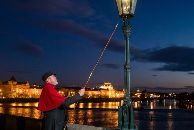 Jan Žákovec v roli lampáře rozsvěcuje plynovou lampu na Karlově mostě | foto:  archiv Plynárenského muzea