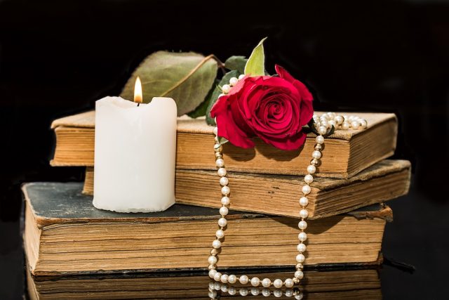 Knihy básní se svíčkou,  růží a perlami | foto: Pixabay