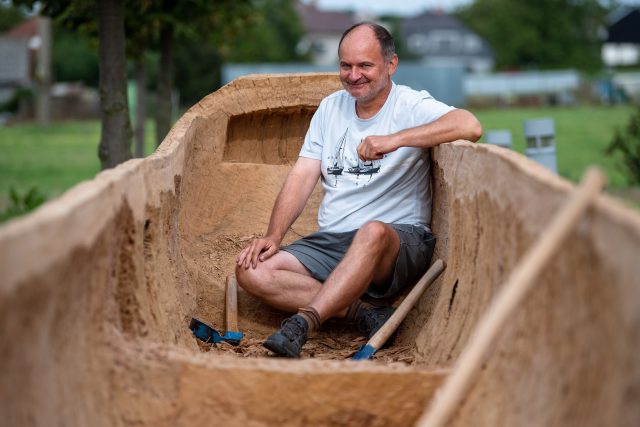 Archeolog Radomír Tichý dokončuje v Archeoparku Všestary plavidlo vydlabané z jednoho kusu kmene | foto: David Taneček,  ČTK