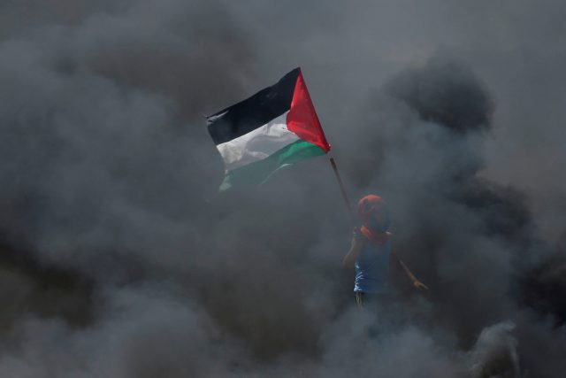 Chlapec s palestinskou vlajkou během protestů proti přesunu americké ambasády z Tel Avivu do Jeruzaléma | foto: Mohammed Salem,  Reuters