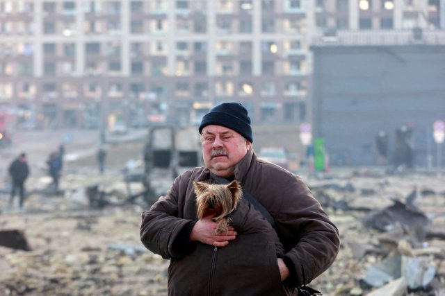 Muž se psem na místě bombardováním poničeného nákupního centra v Kyjevě | foto: Serhii Nuzhnenko,  Reuters