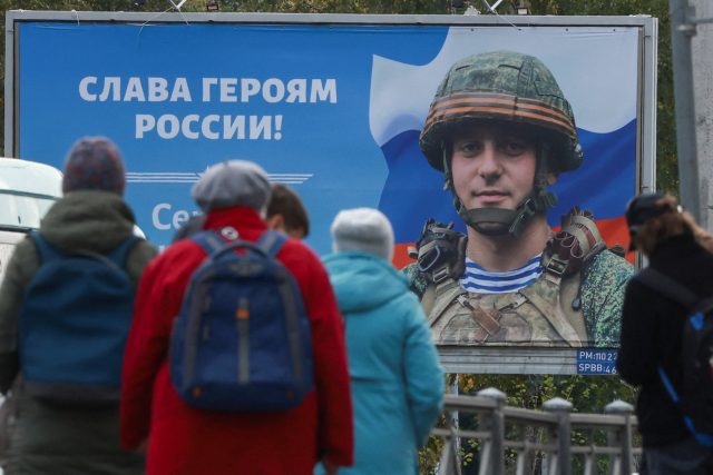 Plakát na petrohradské tramvajové zastávce. Nápis vedle ruského vojáka hlásá: „Sláva hrdinům Ruska!“ | foto: Anton Vaganov,  Reuters