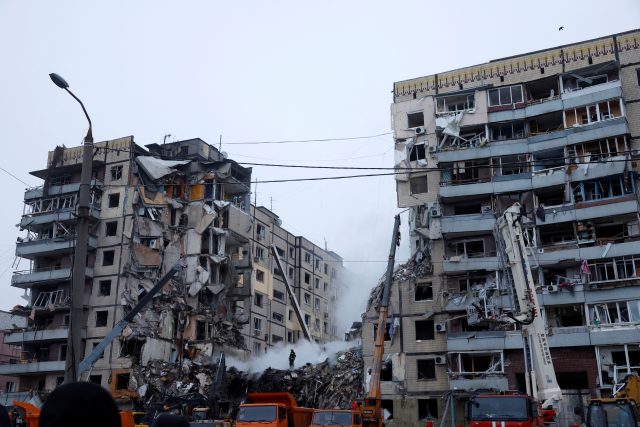 Práce záchranných složek potom,  co obytný dům v ukrajinském Dnipru zasáhla ruská raketa | foto: Clodagh Kilcoyne,  Reuters