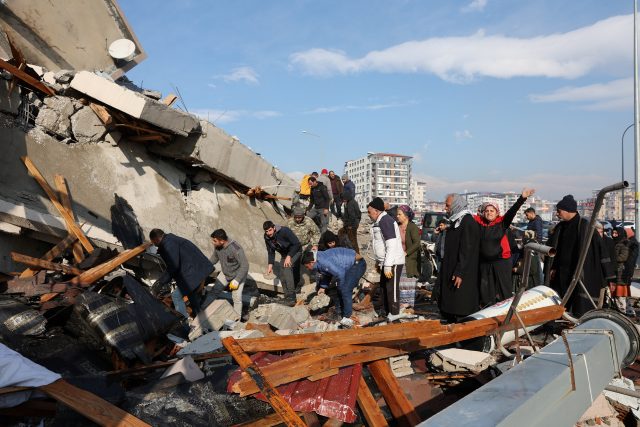 Lidé pátrají po přeživších po zemětřesení v městě Hatay | foto: Umit Bektas,  Reuters