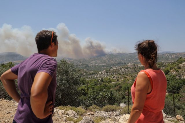 Turisté hledí na požáry u vesnice Archangelos na Rhodosu  (ilustrační foto) | foto: Nicolas Economou,  Reuters