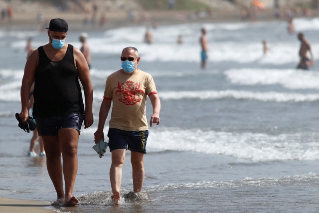 Když se chcete jít projít po pláži ve Španělsku,  roušku si nasadit musíte | foto: Reuters