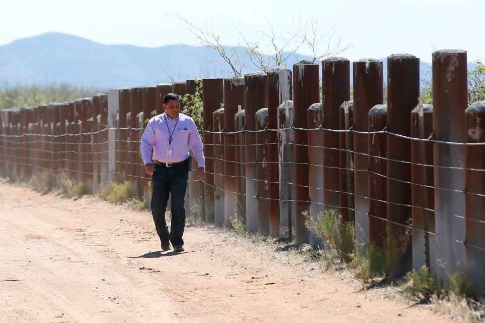 Richard Saunders,  který v rámci kmene Tohono O'odham zajišťuje veřejnou bezpečnost,  se prochází u plotu na hranici mezi USA a Mexikem  (archivní foto) | foto: Rick Wilking,  Reuters