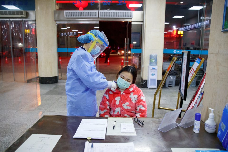 Zdravotní sestra měří teplotu ženě,  která přišla do nemocnice ve městě Jüe-jang. | foto: Reuters