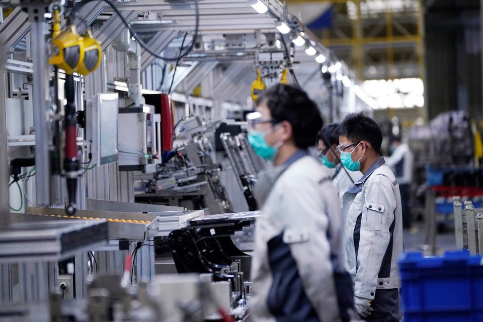 Zaměstnanci v továrně na sestavování autosedaček v čínském Šanghaji nosí roušky | foto: Aly Song,  Reuters