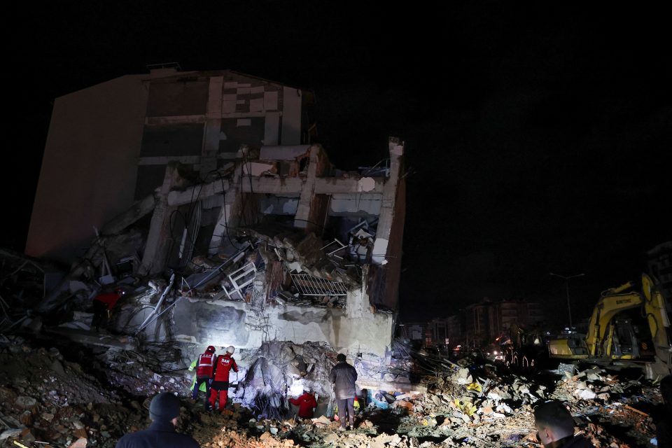 Záchranný tým pracuje na zřícené budově po zemětřesení ve městě Iskenderun | foto: Umit Bektas,  Reuters