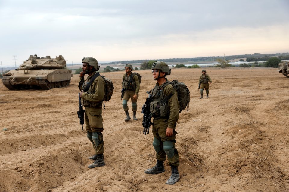 Izraelští vojáci sledují shromažďování izraelských tanků a vojenských vozidel | foto: Amir Cohen,  Reuters