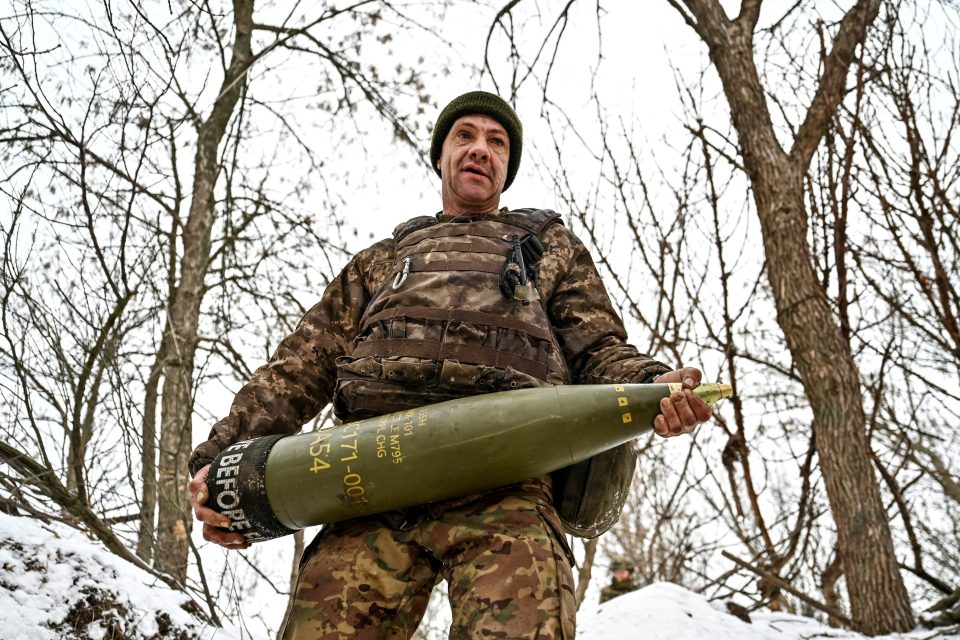 Ukrajinský voják nese 155mm dělostřelecký granát  (archivní foto) | foto: Reuters