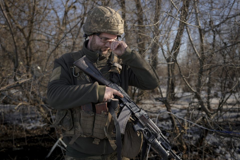 Ukrajinský voják si nastavuje brýle v přední linii v Luhanské oblasti | foto: Vadim Ghirda,  ČTK / AP