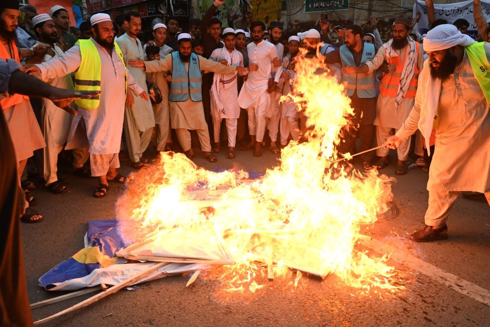 Protesty v pákistánském Láhauru proti pálení koránu ve Švédsku. Demonstrující pálí švédskou vlajku | foto: Arif Ali,  AFP