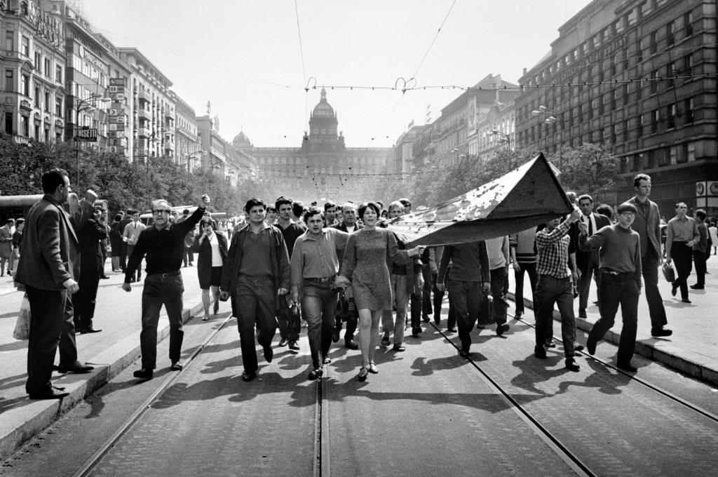 Lidé na Václavském náměstí nesou 21. srpna 1968 zkrvavenou státní vlajku